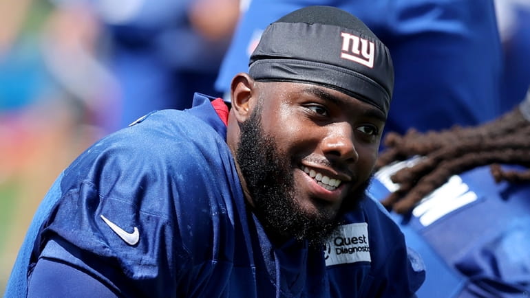 Giants offensive tackle Andrew Thomas stretches after practice during training camp...