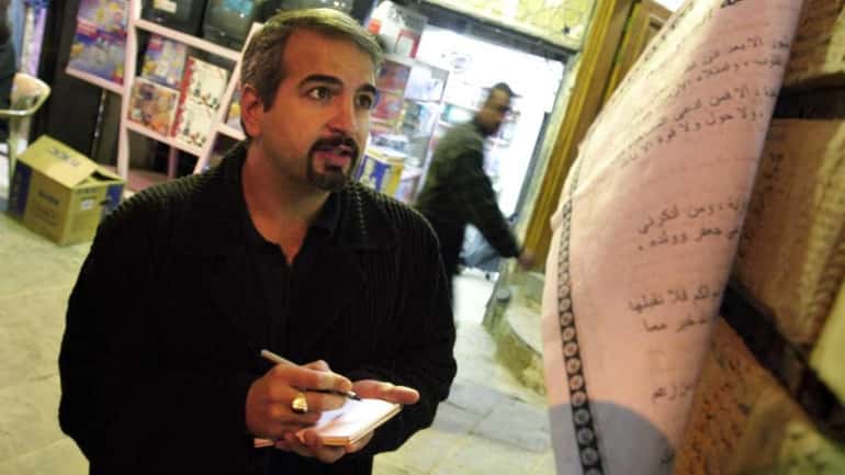 Anthony Shadid takes notes outside Ayatollah Sistani's office in Najaf....