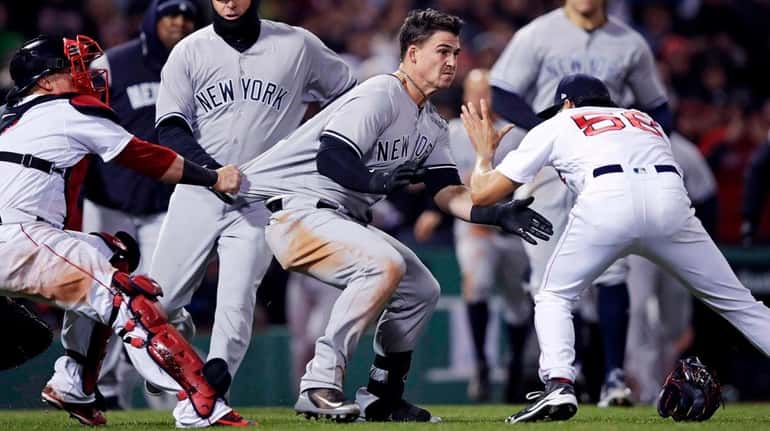 The Yankees' Tyler Austin, center, rushes Red Sox relief pitcher...
