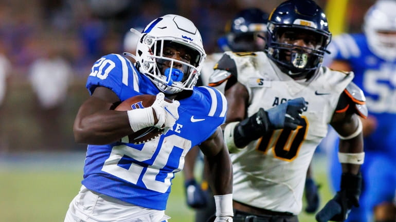 Duke's Jaquez Moore (20) carries the ball past North Carolina...