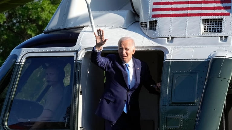 President Joe Biden waves as he boards Marine One on...