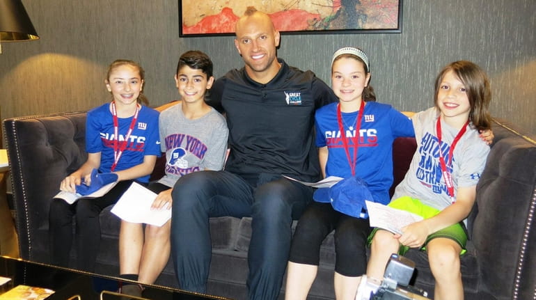 New York Giants player Mark Herzlich with Kidsday reporters, from...