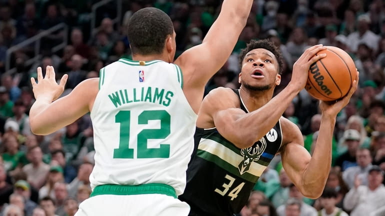Celtics forward Grant Williams defends as Bucks forward Giannis Antetokounmpo looks for...