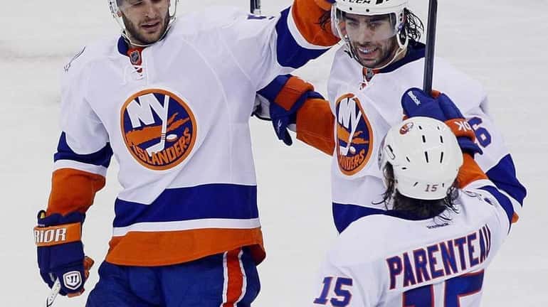New York Islanders' Matt Moulson, center, celebrates his goal with...