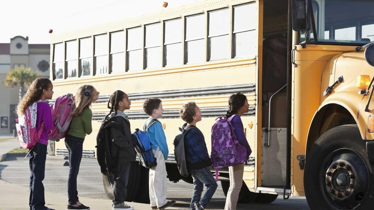 Kids getting on a school bus.