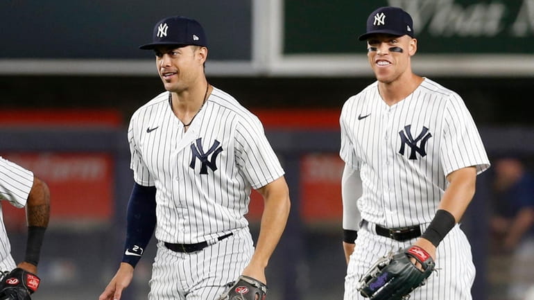 Giancarlo Stanton #27 and Aaron Judge #99 of the Yankees celebrate...