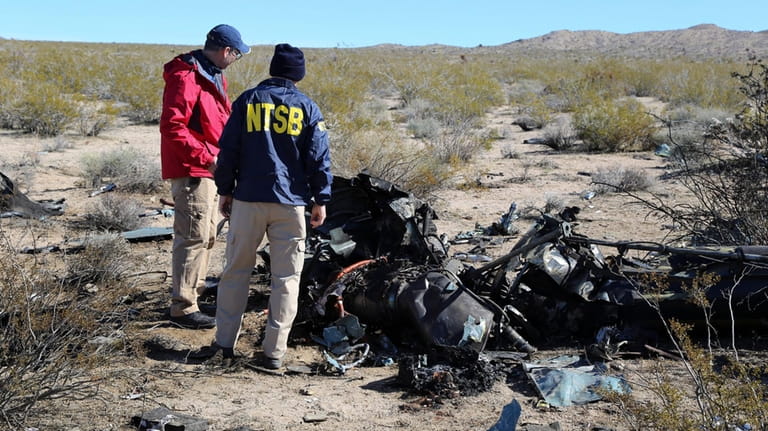 NTSB investigators survey the site of an Airbus Helicopters EC-130...