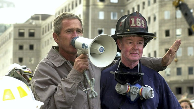 President George W. Bush stands with firefighter Bob Beckwith on...