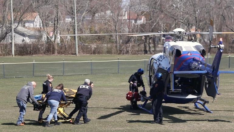 A medic helicopter behind Lindenhurst Middle School as medics tend...