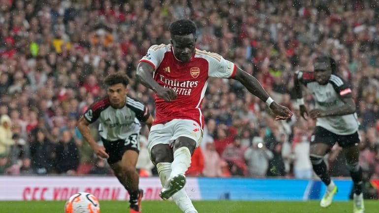 Arsenal's Bukayo Saka shoots to score his side's first goal...