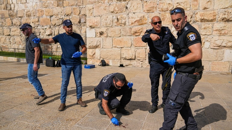 Israeli police inspect the scene of a Palestinian stabbing attack...