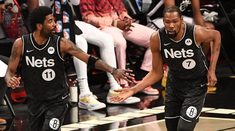 Nets forward Kevin Durant and guard Kyrie Irving slap five...
