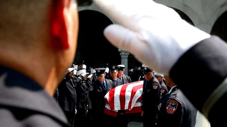 Firefighters carry the coffin of Vincent J. Albanese, 63, of...