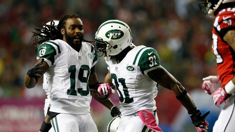 The Jets' Clyde Gates and Antonio Cromartie celebrate a defensive...