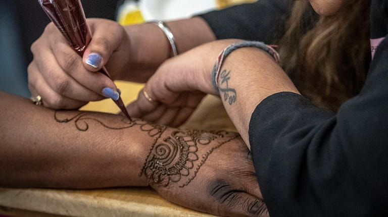 Henna artist Sonam embellishes the hand of certified nursing assistant Natasha Soskey...