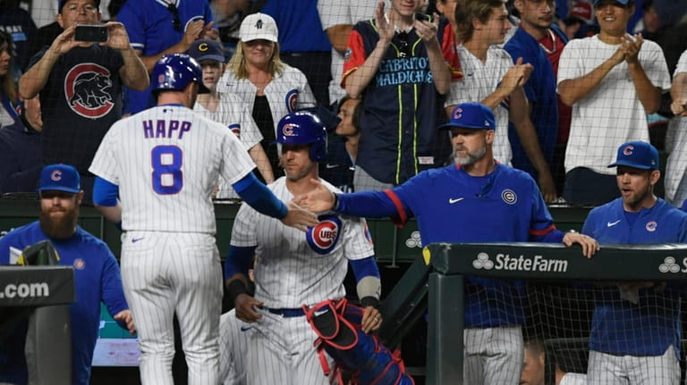 Chicago Cubs' Ian Happ (8) celebrates at the dugout with...