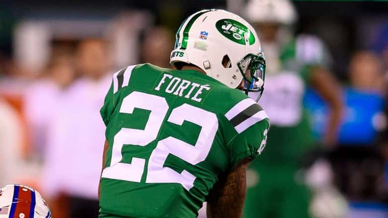 New York Jets running back Matt Forte looks to get...