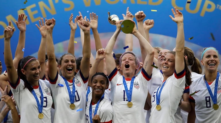 Megan Rapinoe lifts a trophy after the United States won...