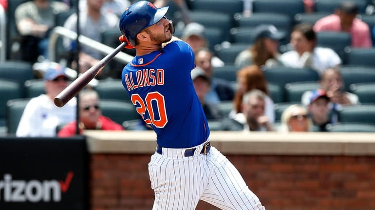 Pete Alonso #20 of the New York Mets follows through...