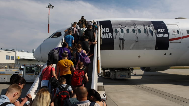 Ukrainian refugees board a plane before flying to Canada, from...
