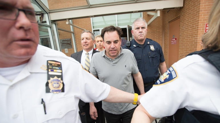 Suffolk County District Judge Robert Cicale is escorted from court...
