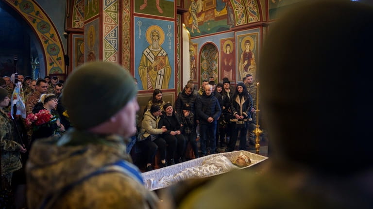 Relatives cry as people, along with Ukrainian servicemen, attend the...