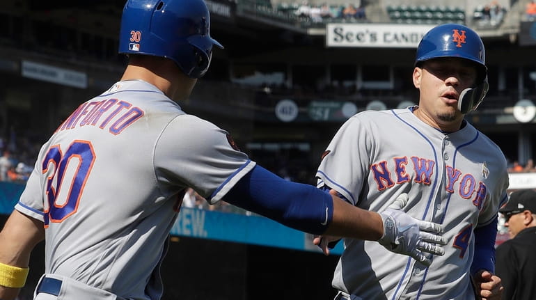 New York Mets' Wilmer Flores, right, is congratulated by Michael...