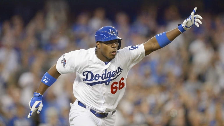 Los Angeles Dodgers outfielder Yasiel Puig reacts after hitting an...