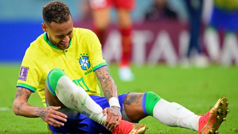 Brazil's Neymar grabs his ankle after an injury during the...