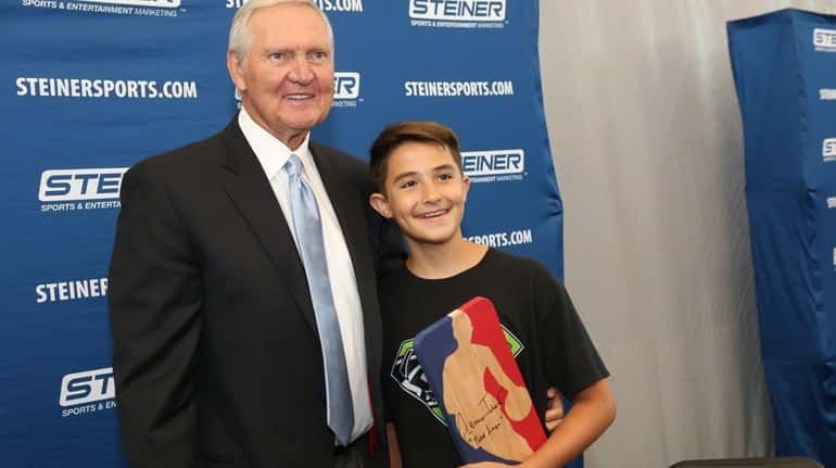 Jerry West poses with Ian Morris as he signs autographs...