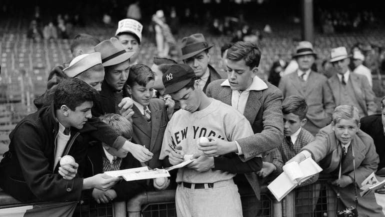 Determined fans of New York Yankees' Joe DiMaggio crowd their...