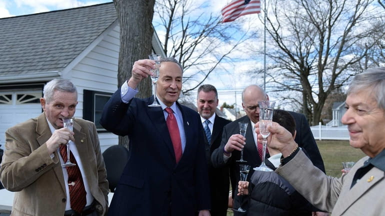 U.S. Senator Charles E. Schumer, second from left, offers a...