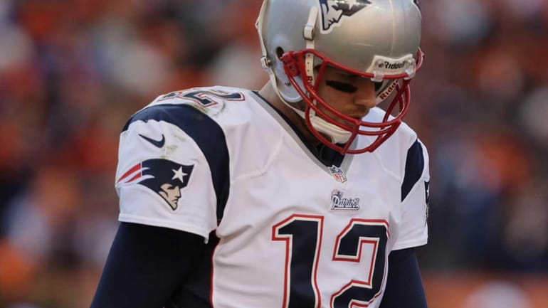 New England Patriots quarterback Tom Brady walks off the field...