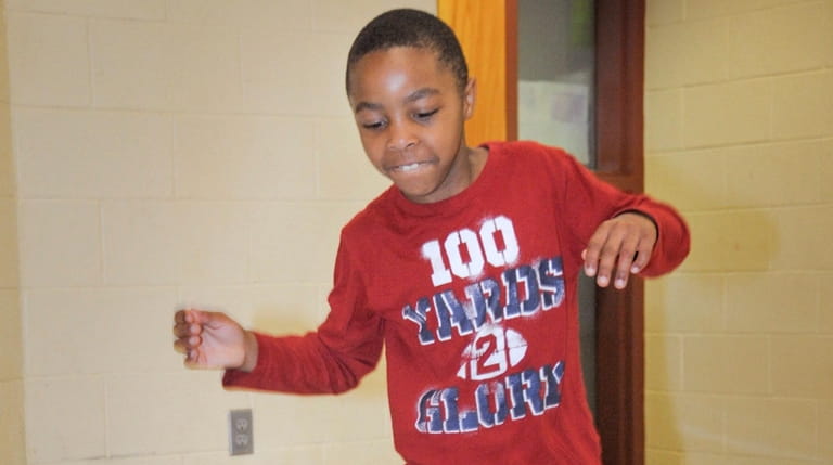 Second-grader Joshua Taylor, 7, hops along the "sensory path" at...
