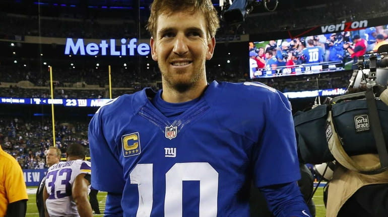 Eli Manning walks off the field after defeating the Minnesota...