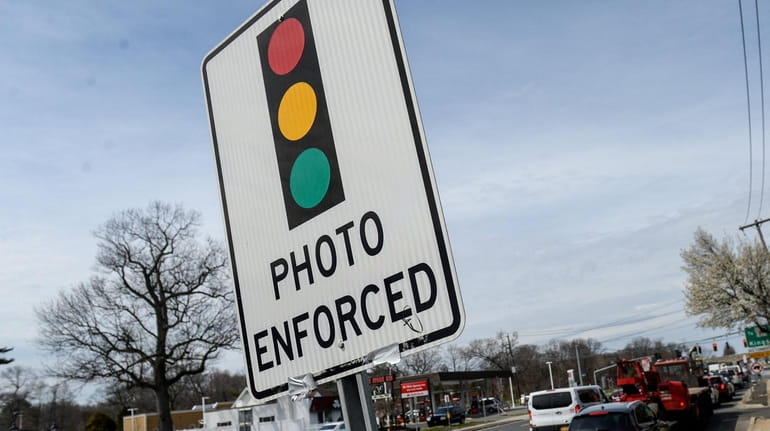 A sign warning of a red-light camera at an intersection...