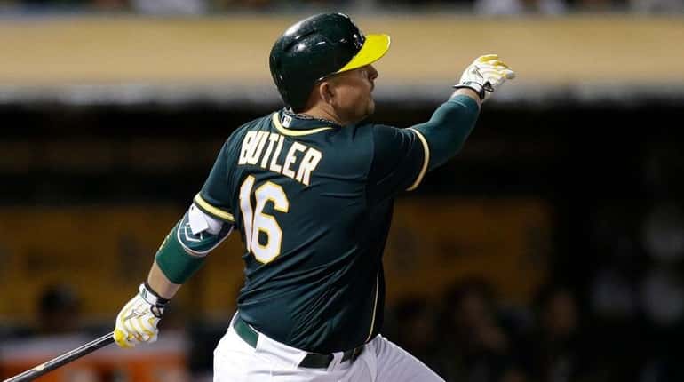 Oakland Athletics' Billy Butler watches his RBI sacrifice fly against...