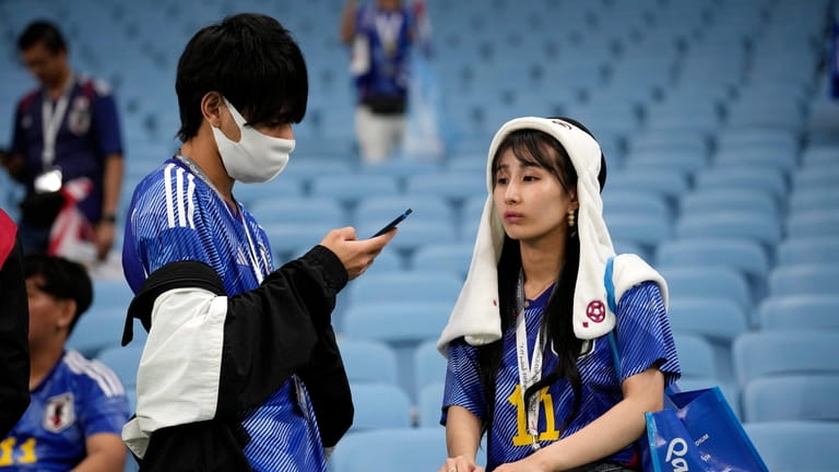 Japan team supporters react after the World Cup round of...