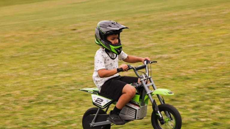 Zach Torres, 7, of Brentwood, rides his electric motorcycle inside...