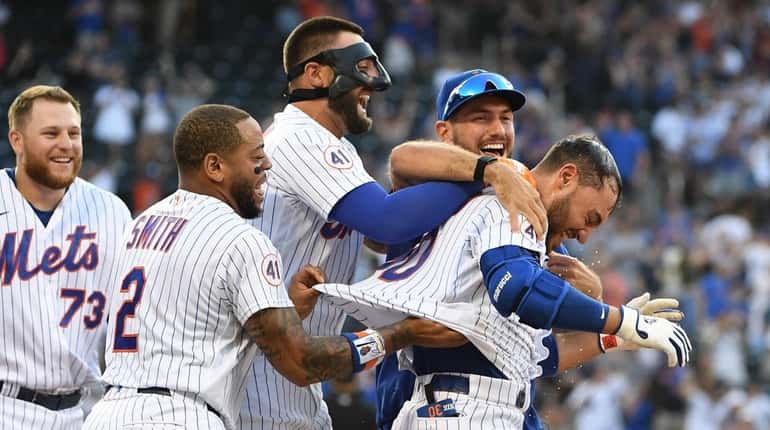  Mets' Michael Conforto is mobbed by teammates after his walk-off...