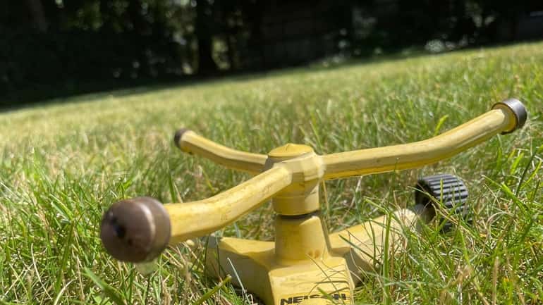 A lawn sprinkler in Suffolk County Sunday. State officials are urging...