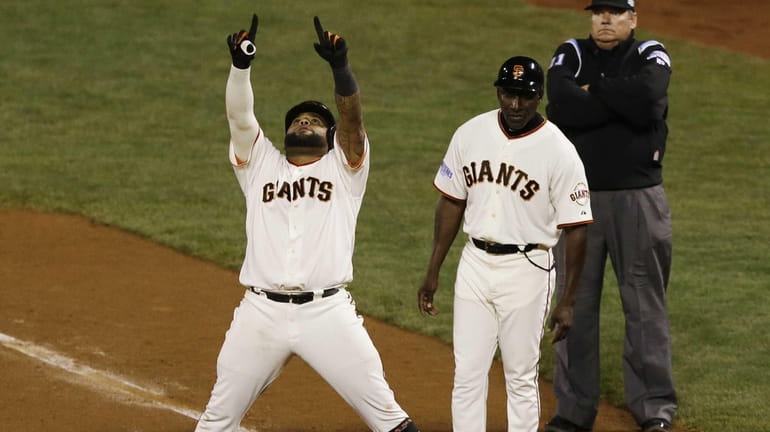 The San Francisco Giants' Pablo Sandoval celebrates while standing at...