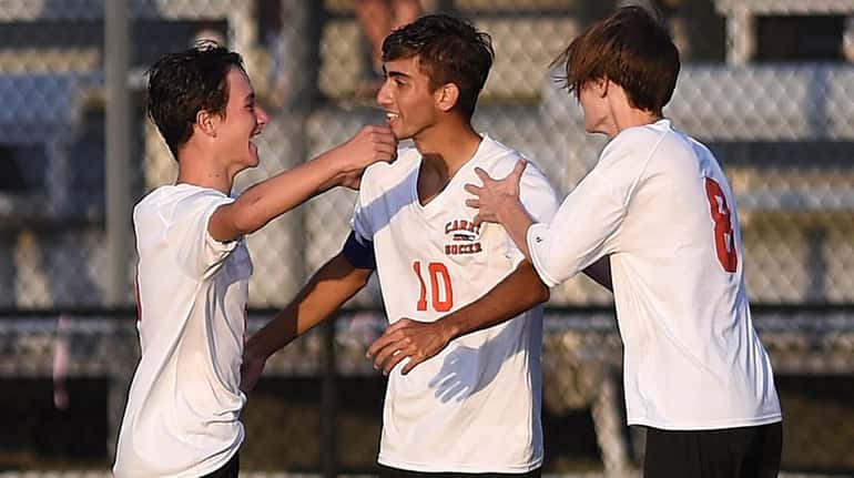 Alessandro Perna #10 of Carey, center, gets congratulated by teammates...
