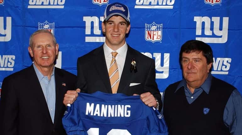 Giants draft pick Eli Manning holds up his new jersey as...
