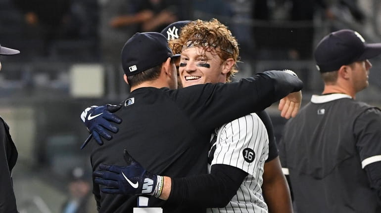 New York Yankees' Clint Frazier is embraced by coaches and...