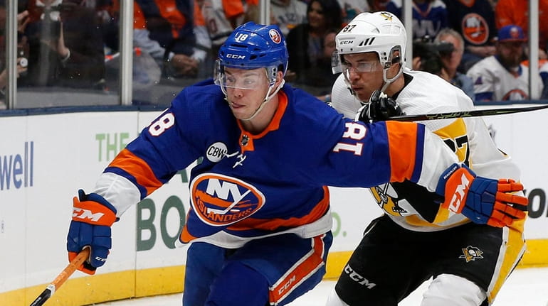 Islanders left wing Anthony Beauvillier and Penguins center Sidney Crosby...