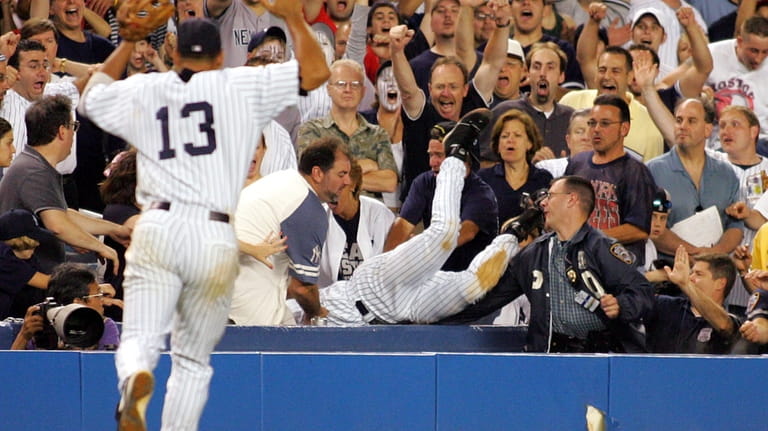 Derek Jeter makes a tremendous catch diving into stands to...