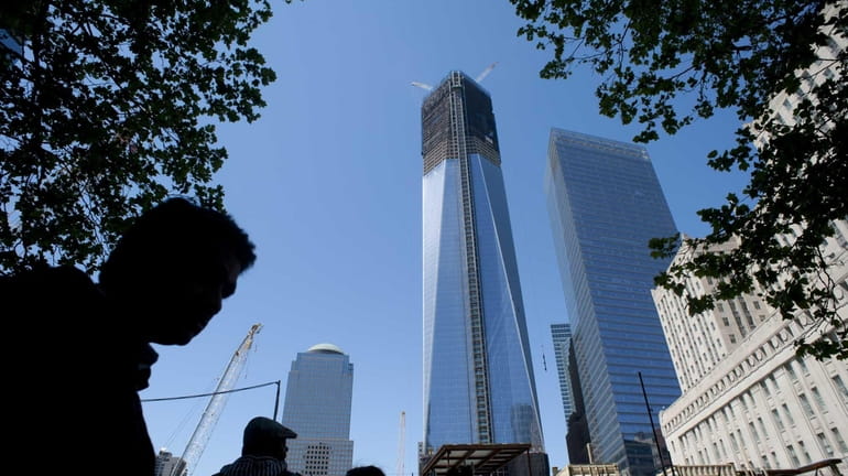 Pedestrians walk past One World Trade Center in lower Manhattan....