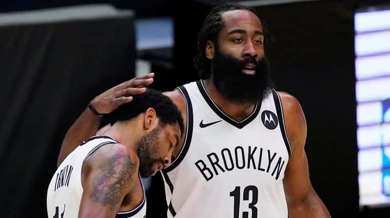 Nets guard Kyrie Irving, left, gets a pat on the...
