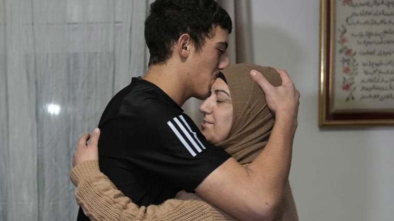 Released Palestinian prisoner Muhammad Abu Al-Humus, 17, hugs his mother...